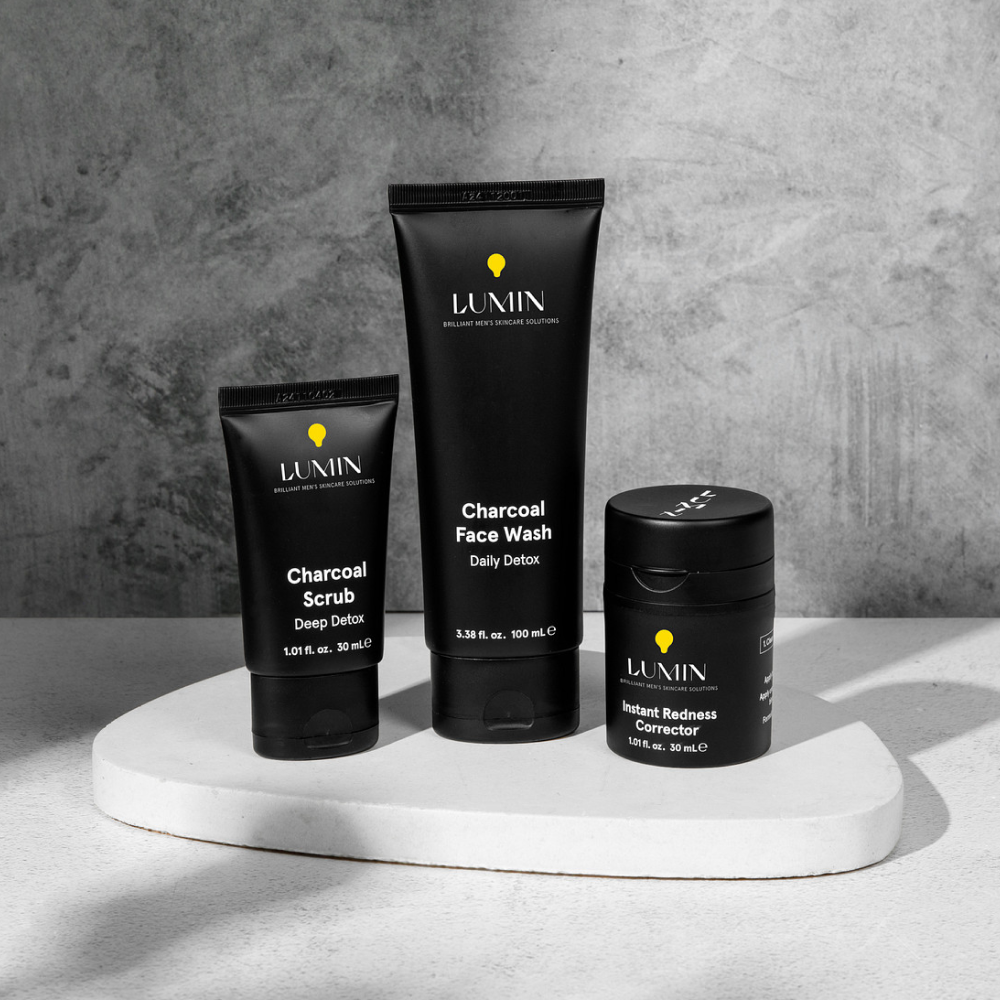 Lumin men's charcoal skincare set featuring Charcoal Scrub, Charcoal Face Wash, and Instant Redness Corrector on white platform