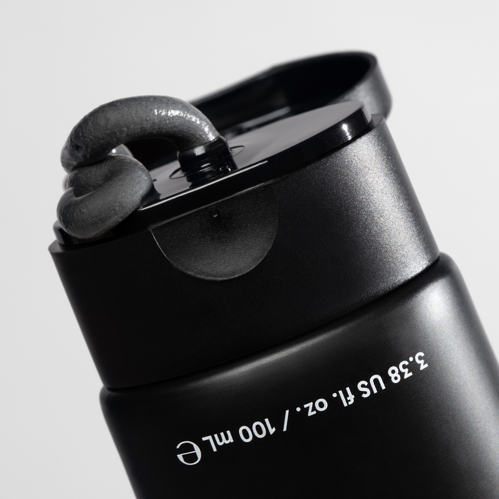 Black squeeze tube with black gel cream dispensed on flip-top cap, labeled 3.38 US fl. oz. / 100 ml skincare product.