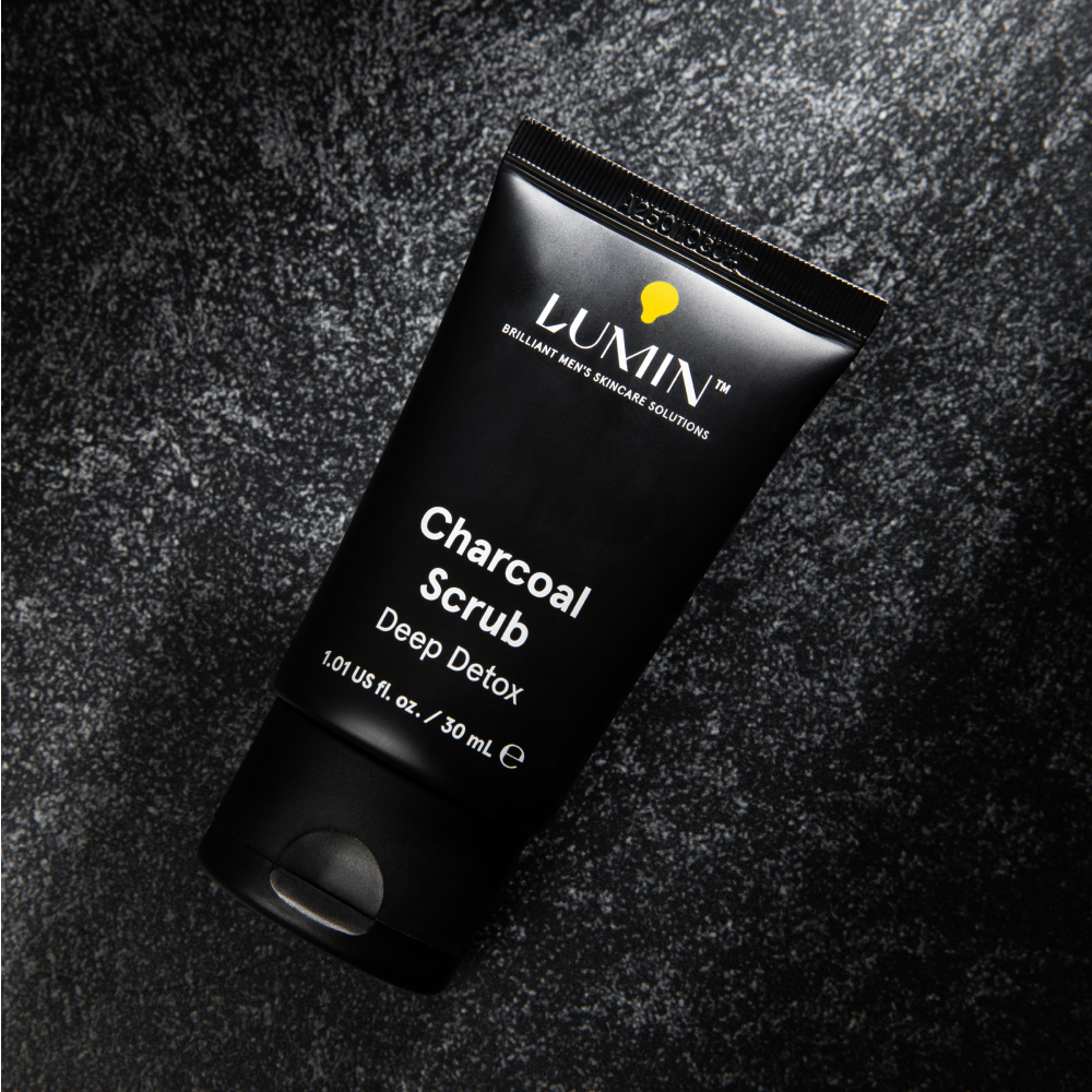 Lumin Charcoal Scrub deep detox skincare tube for men, 1.01 fl. oz, black exfoliating facial cleanser product on dark textured surface