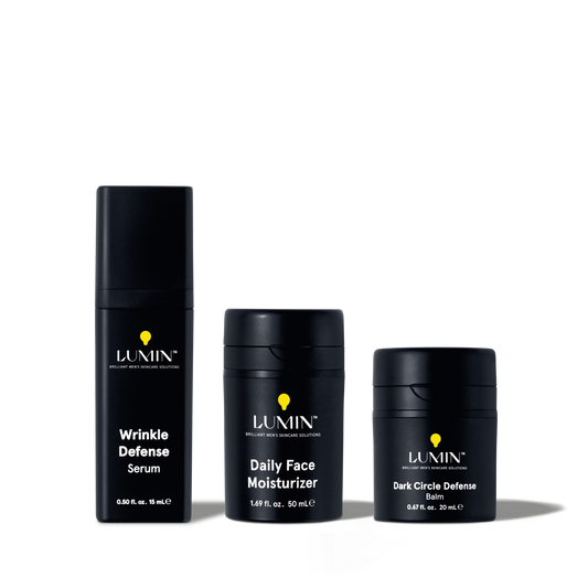 Lumin men's skincare set with Wrinkle Defense Serum, Daily Face Moisturizer, and Dark Circle Defense Balm in black packaging.