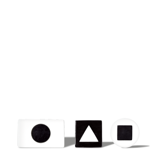 White and black geometric shape blocks with circle, triangle, and square cutouts on black background for educational use.