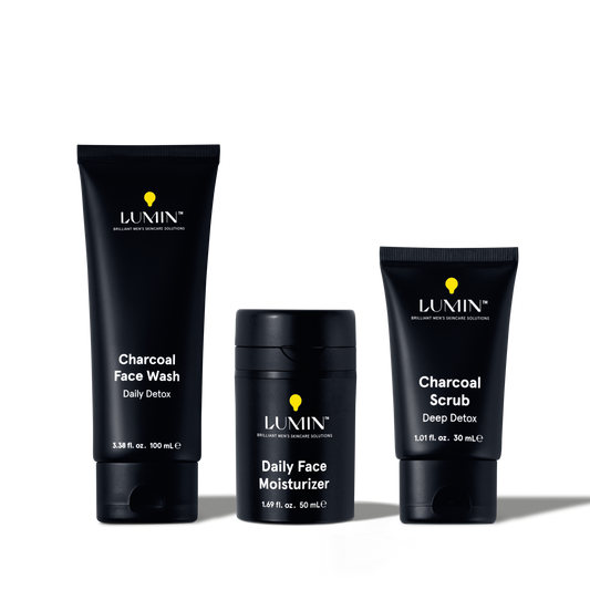 Lumin men's charcoal face wash, daily face moisturizer, and charcoal scrub skincare products in black packaging.